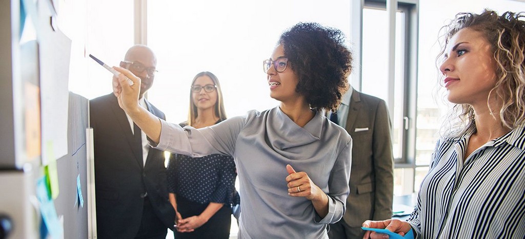 Office employees in front of white board