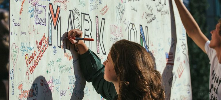 People writing of board with markers